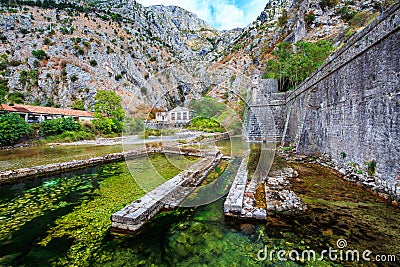 Mediterranean landscape. Overhanging cliffs, old power station near medieval city walls and river. Stock Photo