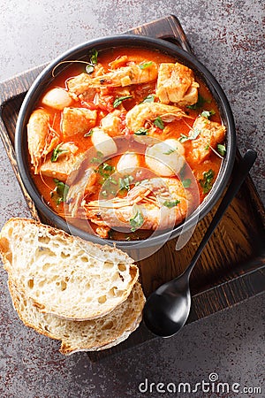 Mediterranean thick stew of seafood and fish with tomatoes close-up in a bowl. Vertical top view Stock Photo