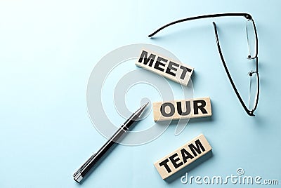 MEET OUR TEAM text on wooden block ,blue background Stock Photo