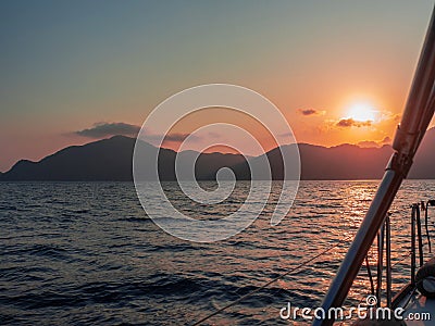 Meet the sunset in the Bay on Board the yacht, a romantic evening at sea. Boat trip on a yacht under sail. Stock Photo