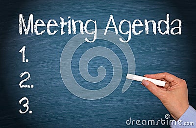 Meeting Agenda - female hand with chalk writing text Stock Photo