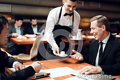 The waiter brought coffee to the businessman. Stock Photo