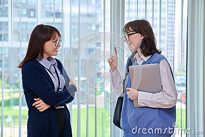 Meeting, conversation of female teacher and girl college student in educational center Stock Photo