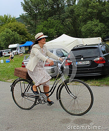 Meeting of Historical Bicycles - a lady in a vintage costume with corresponding bike Editorial Stock Photo