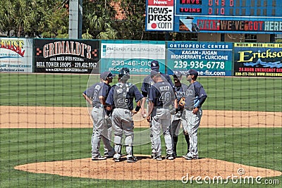 A meeting on the Mound as Seen from Behind the Backstop Editorial Stock Photo