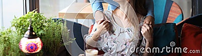 meeting of two girlfriends in a cafe. one came up behind and hugged to greet another girl. holding hands. Stock Photo