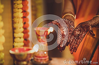 Mehendi on girl& x27;s hand with beautiful composition of flowers and lamps. Indian ritual before wedding. Stock Photo