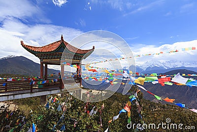 Meili snow mountain with Prayer flags and Chinese style roof, Yunnan, China Stock Photo