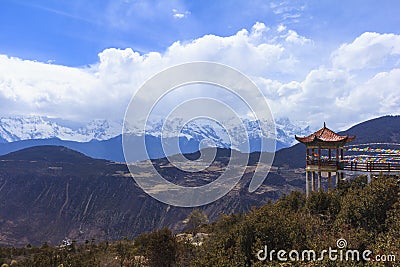 Meili snow mountain with Prayer flags and Chinese style roof, Yunnan, China Stock Photo