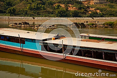 Mekong river, Laos and Thailand at Huay Xai. Traditional wooden boats at sunset Stock Photo