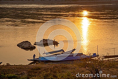 Mekong river, Laos and Thailand at Huay Xai. Traditional wooden boats at sunset Editorial Stock Photo