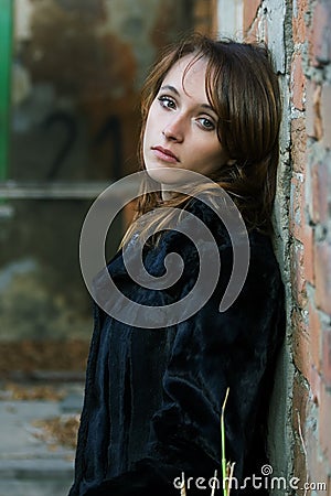 Sad young woman at the wall Stock Photo