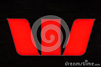 Westpac bank logo closeup glowing in red on dark wall. Editorial Stock Photo