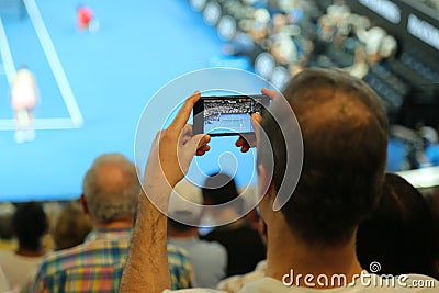 Unidentified spectator uses his cell phone to take images during tennis match at 2019 Australian Open in Melbourne Park Editorial Stock Photo