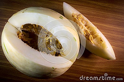 Melon of the snow leopard or matisse or dino variety on a wooden table Stock Photo