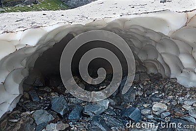 Melt hole under snow patch Stock Photo
