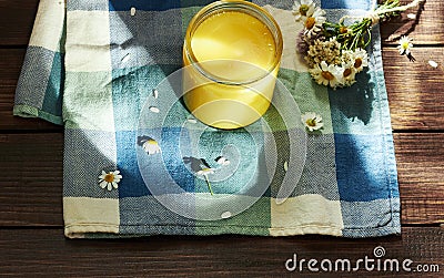 Melted butter ghee in lglass can on textered blue textile Stock Photo