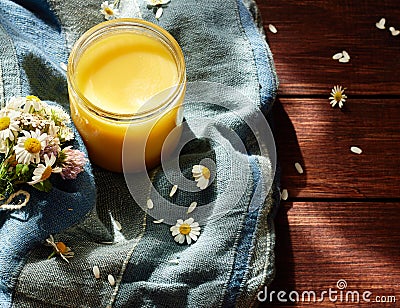 Melted butter ghee in lglass can on textered blue textile Stock Photo