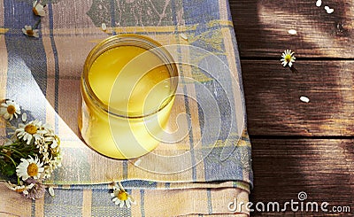 Melted butter ghee in lglass can on textered blue textile Stock Photo