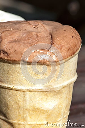 Melting chocolate ice-cream in waffle cup. Outdoors closeup. Stock Photo