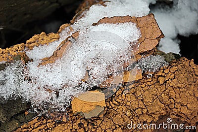 Melting snow on crumbling wall of red bricks Stock Photo