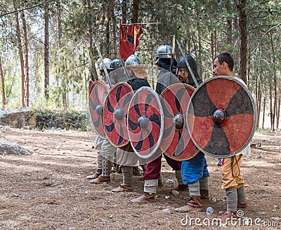Members of the annual reconstruction of the life of the Vikings - `Viking Village` demonstrate combat formation in the forest near Editorial Stock Photo