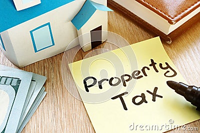 Memo stick with words Property tax and model of house. Stock Photo