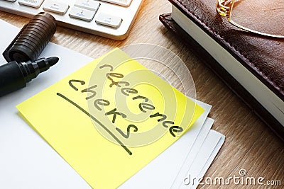 Memo stick with words Reference checks on table. Stock Photo