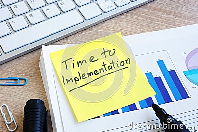 Memo stick with words Time To Implementation. Stock Photo