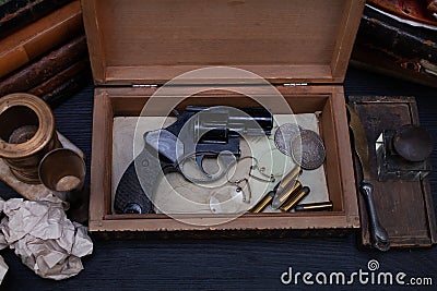 Memorabilia - old vintage revolver gun with ammunitions in wooden box for letters Stock Photo
