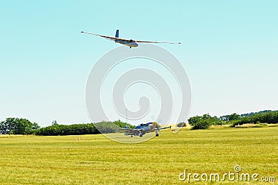 Memorial Airshow. Glider L-13 blank is landing on field airport. Aircraft with turning propeller bellow Editorial Stock Photo