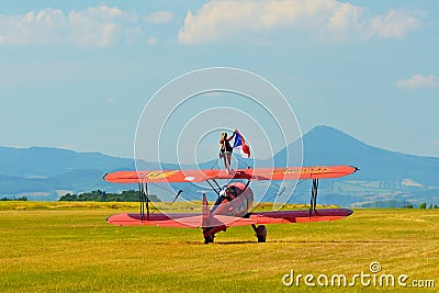 Memorial Airshow. Red Stearman biplane flying towards camera while trailing smoke in exhibition Editorial Stock Photo