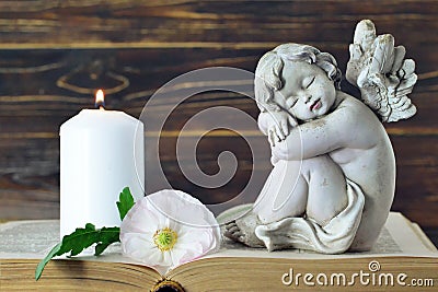 Memorial candle, angel figurine and flower Stock Photo
