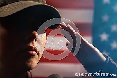 Memorial day. A female soldier in uniform salutes against the background of the American flag. Close-up portrait. Copy space. The Stock Photo