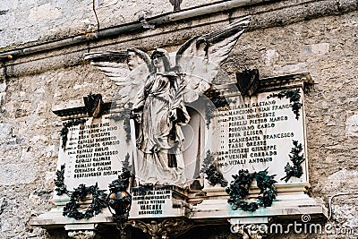 Memorial panel with a sculpture of an angel in the Varenna cemetery, Italy Editorial Stock Photo