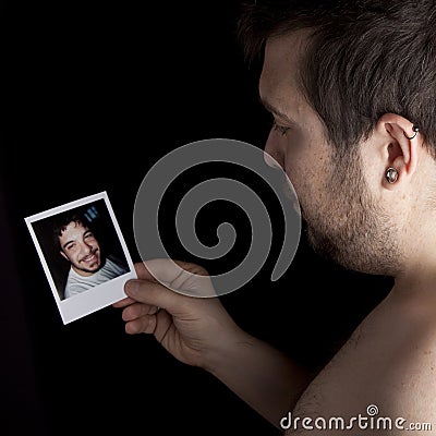 Memories, man looking an old photo of himself Stock Photo
