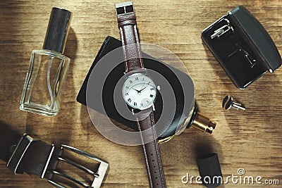 Men accessories: perfume, watch and belt on wooden background Stock Photo