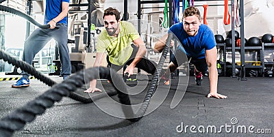 Men with battle rope in functional training fitness gym Stock Photo