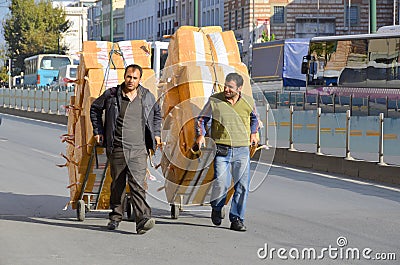 Men carring merchandise in the middle of the street of Istanbul Editorial Stock Photo