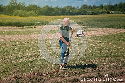 Men clean weeds in the garden Stock Photo