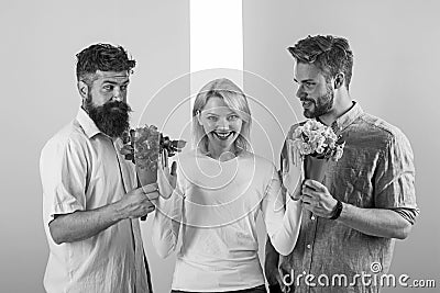 Men competitors with bouquets flowers try conquer girl. Girl smiling reject gifts. Feminism concept. Woman smiling Stock Photo