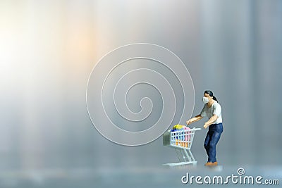 A men doing safe solo shopping at supermarket wearing a face mask. Miniature people figurines toys conceptual photography Stock Photo