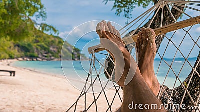 Men feet in Hammock, relaxing on the beach in Haad Rin, Ko Phangan Stock Photo