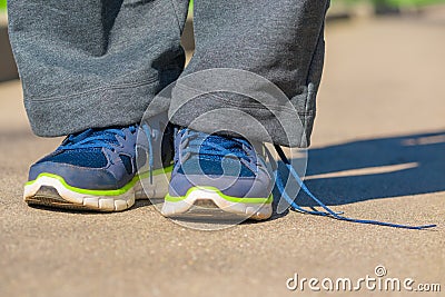 Men feet in sneakers and untied lace Stock Photo