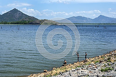 Men fishing on the dam wall at Kandalama Reservoir. Editorial Stock Photo