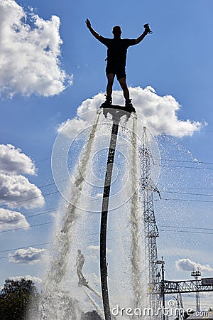 Men on a flyboard with their hands raised to the sky. Extreme sports on the water Editorial Stock Photo