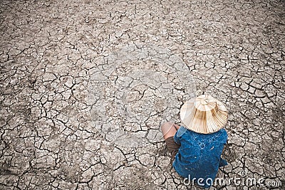 Men on ground cracked dry due to drought. Stock Photo