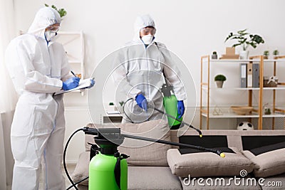 Men in hazmat suits cleaning home, epidemic Stock Photo