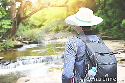 Men hikers mountain nature walking with backpacks and waterfall in the forest adventure travel tourism sports activity Stock Photo