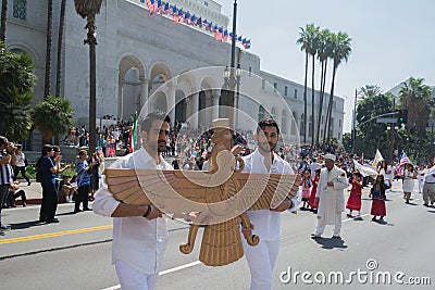 Men holding a sculpture of Faravahar, Iranian symbol Editorial Stock Photo